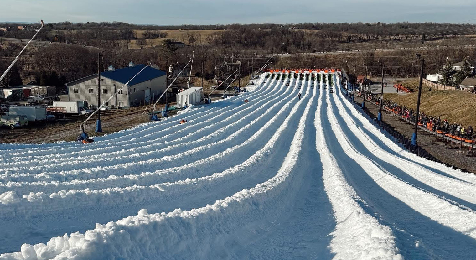 People who are on a tube and who are sliding down a huge snow slide