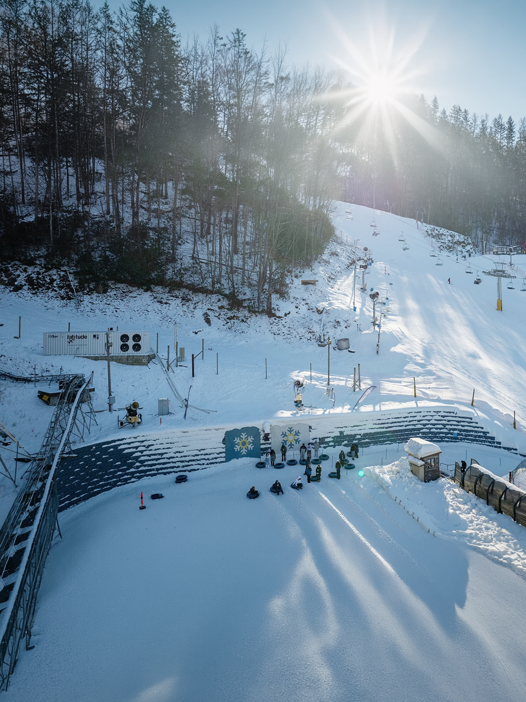 Overview of the Ober Mountain facilities with an L60 machine on the left and people waiting to ski down the slope in front of them.
