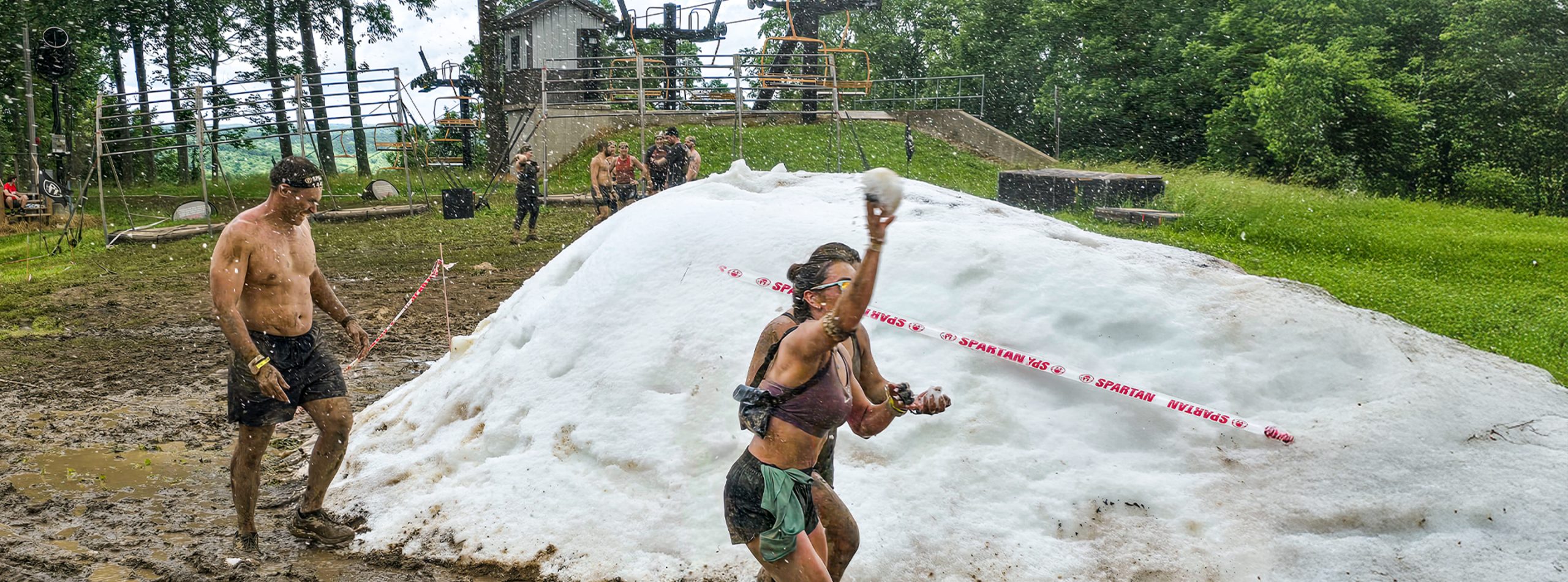 A man and two women near a snowbank during a Spartan Race obstacle course